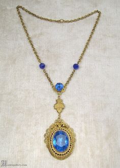 "(Description is below) ALL DELIVERY DATES mentioned by Etsy are ESTIMATES, no delivery date or range is guaranteed, though most of our orders arrive ahead of estimate.  LAYAWAY IS AVAILABLE, typically with a 20% deposit. Please contact us to arrange.  Old, probably late 19th or early 20th century, brass filigree and faceted blue glass pendant necklace in a transitional Victorian / Edwardian style. The largest portion of pendant measures about 2.25\", with a total center drop of just over 4\", t Antique Blue Locket Jewelry, Victorian Blue Locket Jewelry, Blue Victorian Locket Jewelry, Antique Blue Medallion Necklace, Antique Sapphire Filigree Jewelry, Victorian Sapphire Jewelry With Filigree, Antique Sapphire Jewelry With Filigree, Blue Brass Jewelry For Wedding, Antique Blue Necklace With Intricate Design