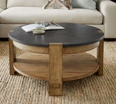 a living room with a couch, coffee table and rug on the floor in front of it