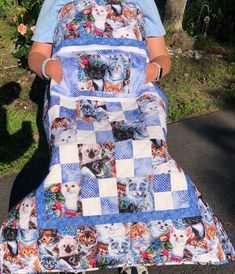 a woman standing next to a blue and white quilt with cats on it's sides