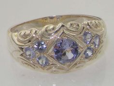 *This ring is made from 925 Sterling Silver with Natural Tanzanite.A beautiful Victorian Style Tanzanite Ring set with a center 4.5mm (0.18" inches)  and six 2.25mm (0.09" inches)  Tanzanites set in a gorgeous 925 Sterling Silver setting. PLEASE MAKE SURE YOU STATE THE FINGER SIZE YOU REQUIRE WITH YOUR PAYMENT AND PROVIDE YOUR TELEPHONE NUMBER FOR DELIVERY COURIER.This is a very comfortable and easy ring to wear being that it sits close to the finger, and the delightful carved design around the Tanzanite Ring, Scroll Design, Funky Jewelry, Natural Tanzanite, Dream Jewelry, Jewelry Inspo, Pretty Jewellery, Cute Jewelry, Solid 925 Sterling Silver