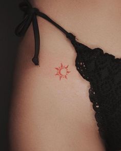 a close up of a woman's stomach with a small tattoo on her left side