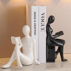 two white and black figurines sitting next to each other