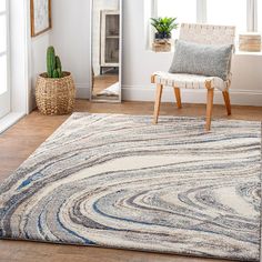 a living room area with a rug, chair and mirror