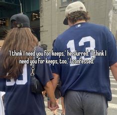 two people walking down the street holding hands with one person wearing a jersey that says, i think i need your for keeps