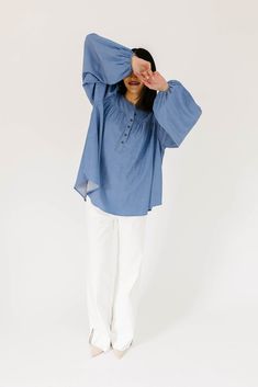 this retro-inspired long sleeve top will take you from summer picnics to fall photoshoots with ease. made with a dark wash denim-esque material, this elevated top features long balloon sleeves + a flowy silhouette. dress it up with trousers + heels, or down with white jeans + sandals. medium wash // high neckline, buttons, balloon sleeves, elastic cuffs paired with our camelot wide leg denim model is 5'8" + wearing a small measurements are approximate + taken while laying flat small : bust 42” l Chic Fall Peasant Top With Lantern Sleeves, Chic Lantern Sleeve Peasant Top For Fall, Cotton Blouse With Elastic Sleeves And Relaxed Fit, Casual Flowy Peasant Top With Lantern Sleeves, Casual Peasant Top With Flowy Lantern Sleeves, Casual Flowy Lantern Sleeve Peasant Top, Flowy Bishop Sleeve Tops For Fall, Fall Peasant Top With Lantern Sleeves, Fall Peasant Top With Gathered Lantern Sleeves