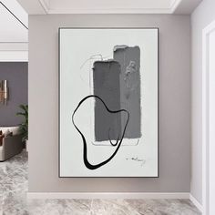 an abstract painting hangs on the wall in a modern living room with grey walls and flooring