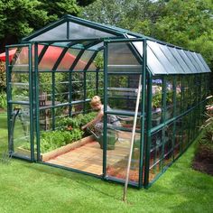 a small green house sitting on top of a lush green field