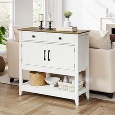 a living room with white furniture and wood floors