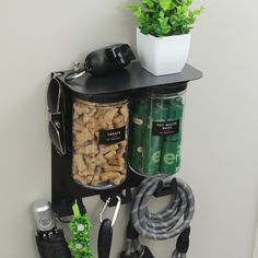 a black shelf with various items and a potted plant next to it on the wall