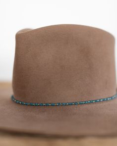 This hat band mixes beautiful faceted glass beads with brass accents to create a subtle sparkle to add to your hat. Material: Faceted glass beads & brass beads Dimensions: 21" beaded length Closure: Adjustable slide closure Color Options: Black, Gray, Beige, Blue Handmade by Crossbow in the mountains of Telluride, CO. Beaded Hat Bands, Beaded Hat, Brass Beads, Belt Purse, Crossbow, Brass Accents, Accessories Bags Purses, Hat Band, Faceted Glass