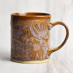 a brown coffee mug sitting on top of a white table