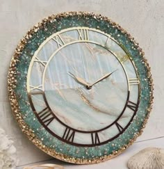 a clock that is on the side of a wall next to shells and seashells