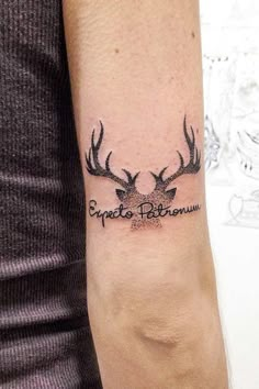 a person with a tattoo on their arm has a deer head and the words escape believe