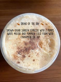 a drink in a plastic cup with cinnamon toppings on the side and an information label