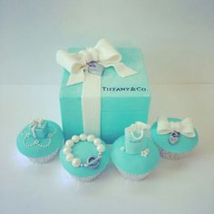 there are cupcakes and cakes in the shape of a box with pearls on them