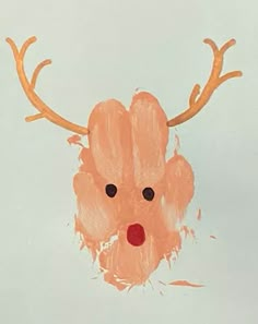 a child's handprint of a deer with antlers on it, in front of a light blue background