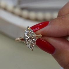 a woman's hand holding a ring with a large diamond on top of it