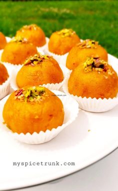 several muffins on a white plate with grass in the background