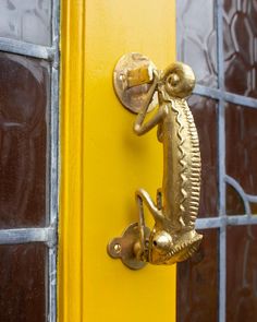 a close up of a door handle on a yellow door