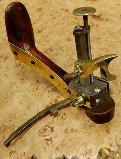 an old fashioned sewing machine sitting on top of a piece of wood next to a pair of scissors