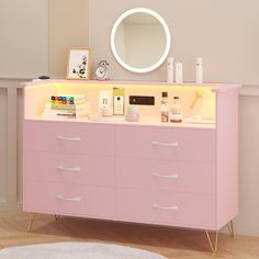 a pink dresser with various items on it and a round mirror above the top shelf