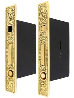 two black and gold door handles with ornate designs on them, one has a keyhole in the middle