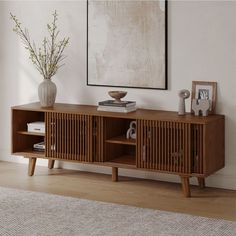 a wooden entertainment center sitting on top of a hard wood floor next to a white wall