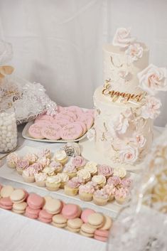 a table topped with lots of cakes and cupcakes