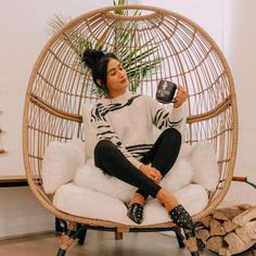 a woman sitting in a chair holding a cup