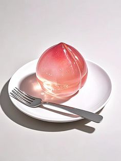 an apple sitting on top of a white plate next to a fork