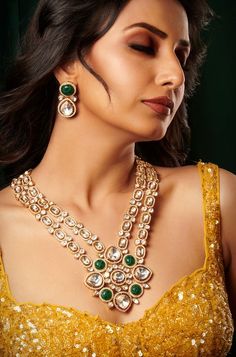 Introducing an exquisite double-layer Kundan necklace adorned with radiant Kundan stones, accompanied by matching earrings, all set in mixed metal with opulent 22kt gold plating, offering an enchanting blend of tradition and elegance. Finish: 22KT Gold Plating Material: Brass, Kundan Color: Gold, Green & White Size: Free Size, Adjustable Closure Type: Draw String Box Contains: 1 Necklace, 1 Pair of Earrings Gold Emerald Necklace For Reception, Festive Kundan Emerald Necklace For Receptions, Gold Emerald Necklace For Formal Festivals, Formal Gold Emerald Necklace For Festivals, Festive Jewelry Sets With 17 Jewels For Celebration, Elegant Kundan Chandbali Necklace With Gemstone, Gold Chandbali Bridal Necklace With 17 Jewels, Gold Emerald Necklace With Intricate Design For Reception, Traditional Gold Emerald Necklace For Reception