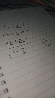 a notebook with hearts drawn on it and lined in sheets of paper next to a pen