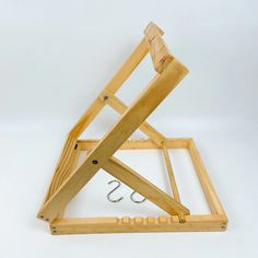 a wooden frame with hooks attached to it and two pieces of wood sitting on top of each other