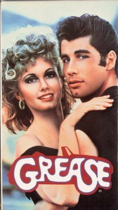 the cover of grease on a wooden table with a man and woman standing next to each other