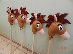 five horse head on sticks are lined up against the wall