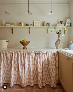 a kitchen counter with a bowl of fruit on it and shelves in the back ground