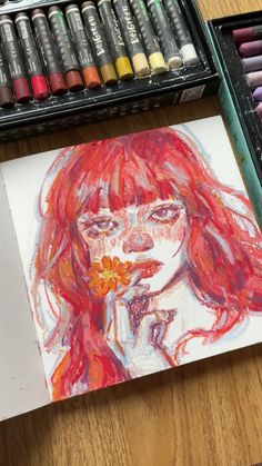 a drawing of a woman with red hair and flowers in her mouth next to some crayons