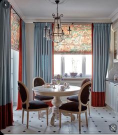 a dining room table with four chairs and a chandelier hanging from the ceiling