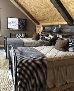 two beds in a room with wooden walls and carpeted flooring, one has a black and white checkered comforter on it