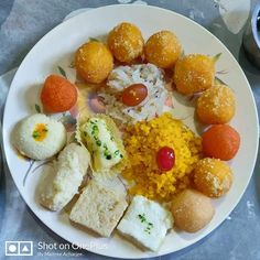 a white plate topped with different types of food on top of a table next to cups and saucers