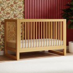 a small wooden crib in front of a red wall