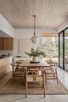 a dining room table with chairs and a potted plant on top of the table