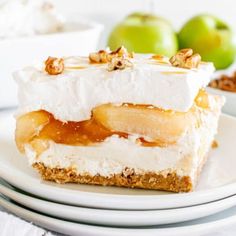 a piece of dessert sitting on top of a white plate next to two green apples