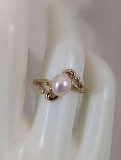 a close up of a ring with a pearl on it