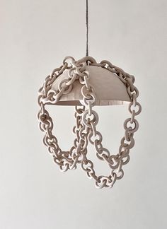 Organic modern ceramic chain pendant light, Ceramic chain chandelier, ceramic pendant light, Rustic pendant light, unique pendant light   EXPECT 5-6 WEEKS FOR ORDER TO SHIP   The ceramic chandelier  is a captivating piece of art that seamlessly blends earthy, organic modern aesthetics with a nomadic, bohemian or beachside interior vibe.  Materials: The chandelier's core structure is composed of hand built and pinched  speckled stoneware dome, adorned with meticulously shaped stoneware chains. The choice of speckled stoneware and hemp wrapped  hanging wire as the primary materials lends the chandelier a rustic and earthy quality. Ceramic Chains: The standout feature of this chandelier is the delicate ceramic chains that cascade from the central body, creating a harmonious visual connection. Chandelier Ceramic, Ceramic Light Fixture, Sculptural Chandelier, Ceramic Chain, Thorns Tattoo, Ceramic Chandelier, Rustic Pendant Light, Glass Wall Sculpture, Chain Chandelier