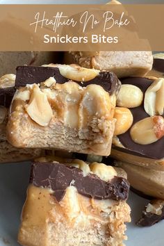 several pieces of peanut butter no bake snickkers bites stacked on top of each other