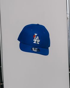 New Era 9FIFTY FIT: Features a classic, throwback look with a flat visor that can curve with a full crown. Includes a structured front panel for stability and an open back with snapback closure. 100% polyester Structured High-profile 7-position adjustable snap closure Please give us 1-4 business days before your order is shipped out. Blue Flat Bill Baseball Cap For Spring, Blue Fitted Hat With Flat Brim For Streetwear, Blue Flat Brim Fitted Hat For Streetwear, Blue Flat Brim Hat For Streetwear, Blue Baseball Cap For Streetwear, Blue Flat Bill Baseball Cap For Streetwear, Blue Baseball Cap For Streetwear During Baseball Season, Throwback Adjustable Trucker Baseball Cap, Blue Snapback Fitted Hat For Streetwear