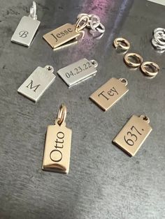 "A sideways display of your name, initials, or a short word makes for an intriguing look with our sleek tag charm. We will engrave your name or message in vertical display on this 14k gold-filled shiny pendant and ring to hang on your own chain. CHAIN NOT INCLUDED Free Engraving for a limited time! CHARM DETAILS * 14k gold-filled or 925 sterling silver * Tag measures 13.5mm x 6mm (.53\" x .23\") * Large jump ring to slide on to your favorite chain * Choice of several fonts and design layouts * U Small Blank Rectangular Sterling Silver Writeable Gift Tag, Dainty Personalized Charms For Anniversary, Classic Personalized Charms For Anniversary, Personalized 14k Gold Minimalist Charms, Classic Engraved Charms For Gift, Minimalist 14k Gold Personalized Charms, Meaningful Personalized Rectangular Jewelry, Sterling Silver Nameplate Charms Jewelry, Classic Personalized Sterling Silver Charms