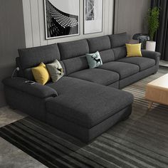 a living room with grey couches and yellow pillows on the floor next to a coffee table