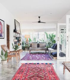 a living room filled with furniture and lots of plants